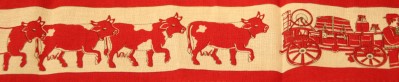 Tablecloth design of Swiss cows and wagon.